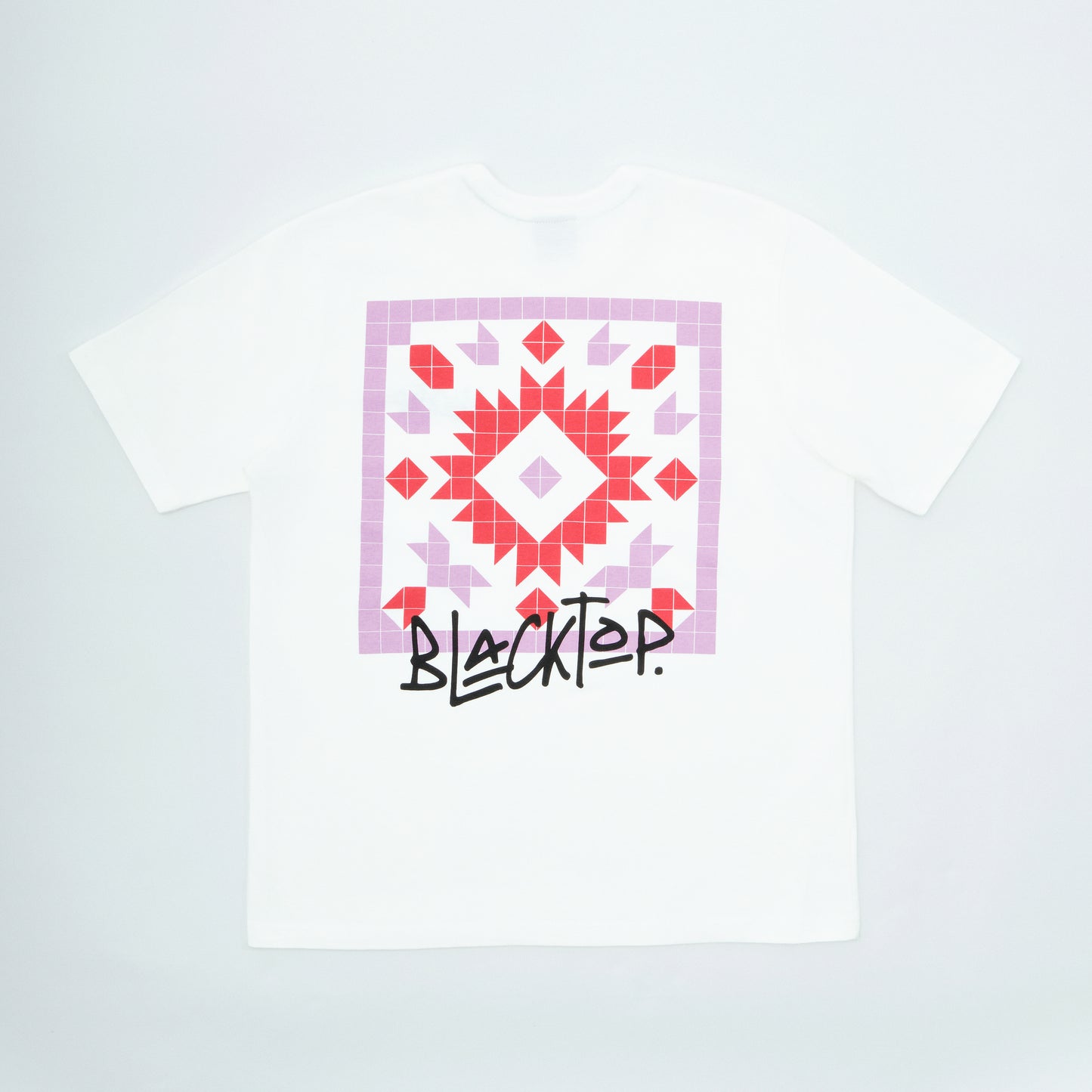White t-shirt with a geometric pattern and 'Blacktop' text on a light gray background