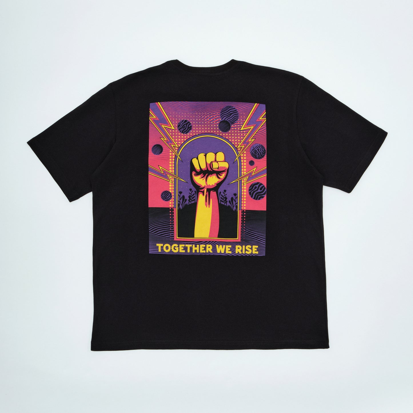 Black t-shirt with a colorful graphic of a raised fist and 'Together We Rise' text on a light gray background